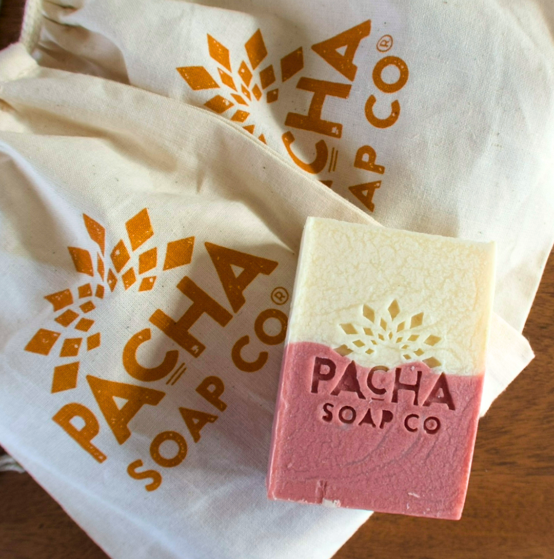 Pink bar of soap with 'Pacha Soap Co' branding on a white cloth background
