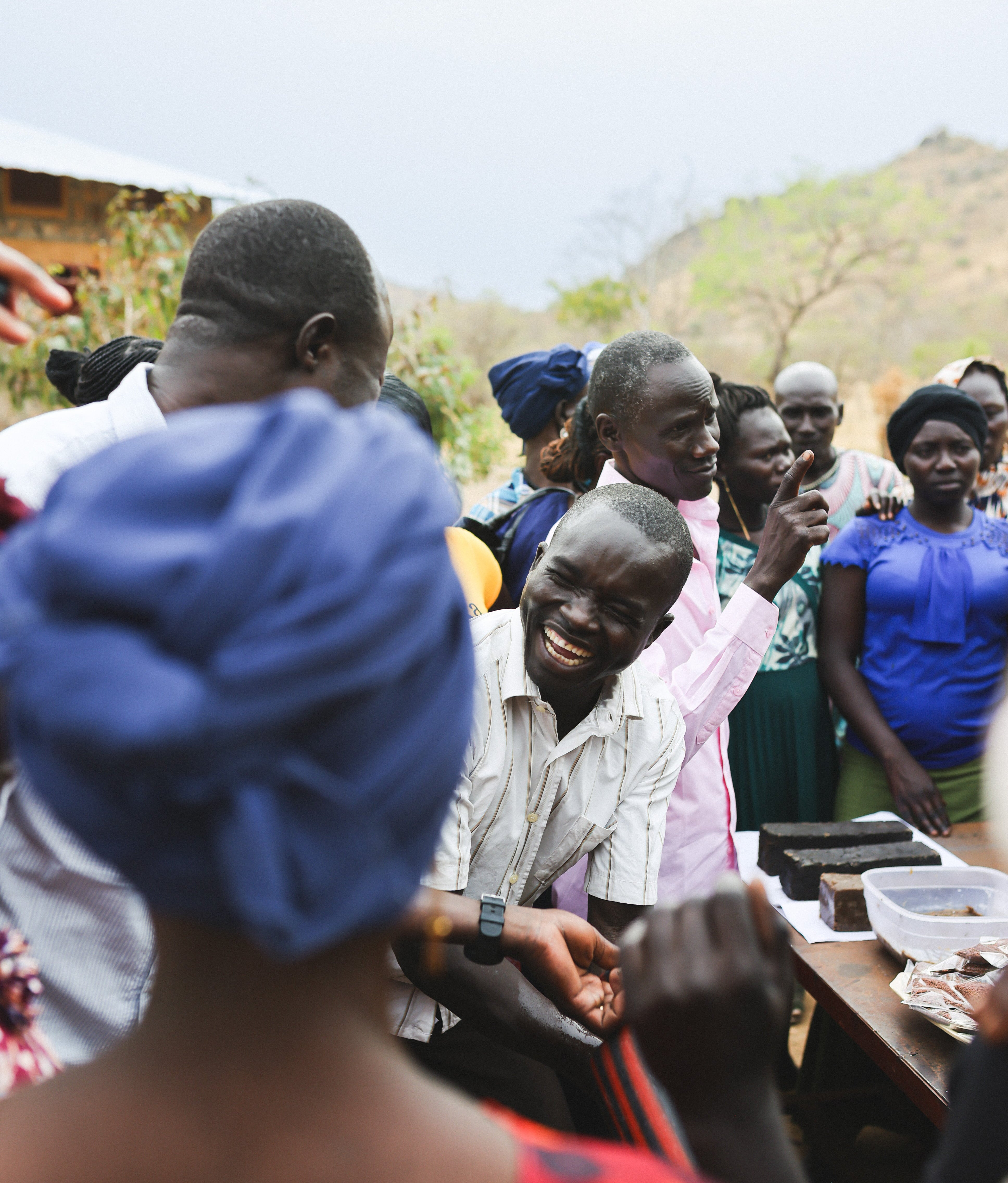 Group of people gathered outdoors with a mountainous background