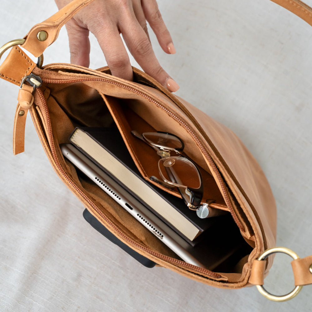 The Newport Tote resting on a picnic blanket, showcasing its utility as a fashionable leather bucket tote bag.