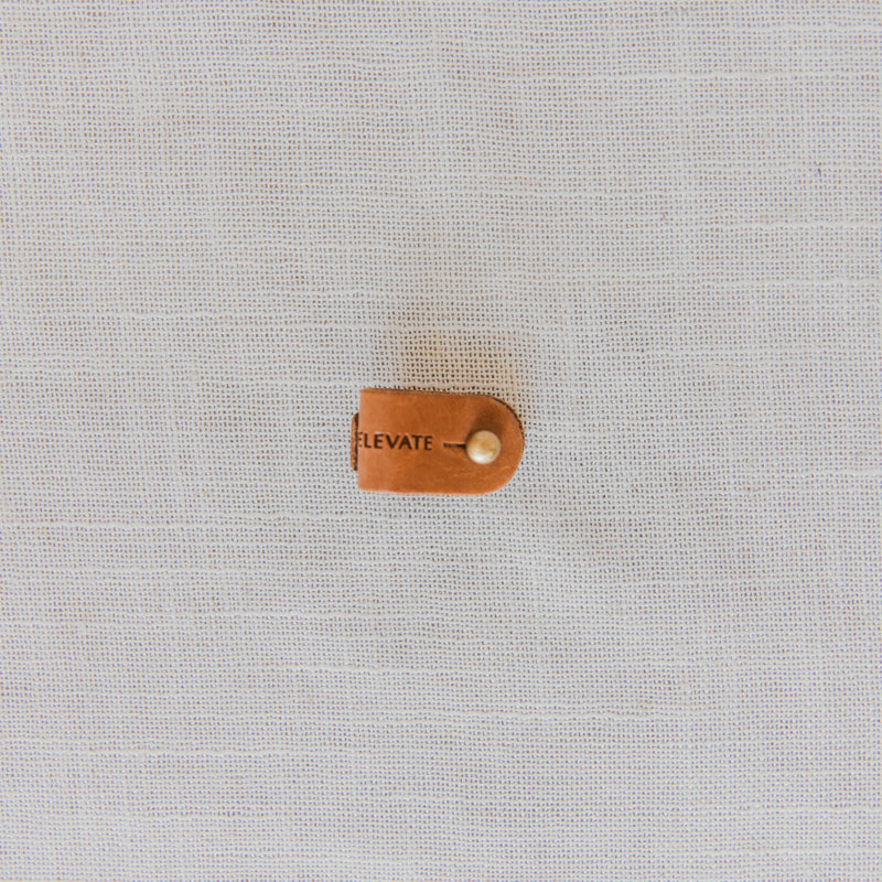 Leather Cord Wrap Organizer neatly coiled with a strap, illustrating tangle-free convenience for electronics.