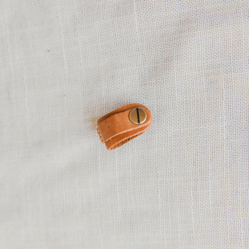 Beautifully crafted Leather Cord Wrap Organizer showcasing its compact design to easily fit in bags or pockets.