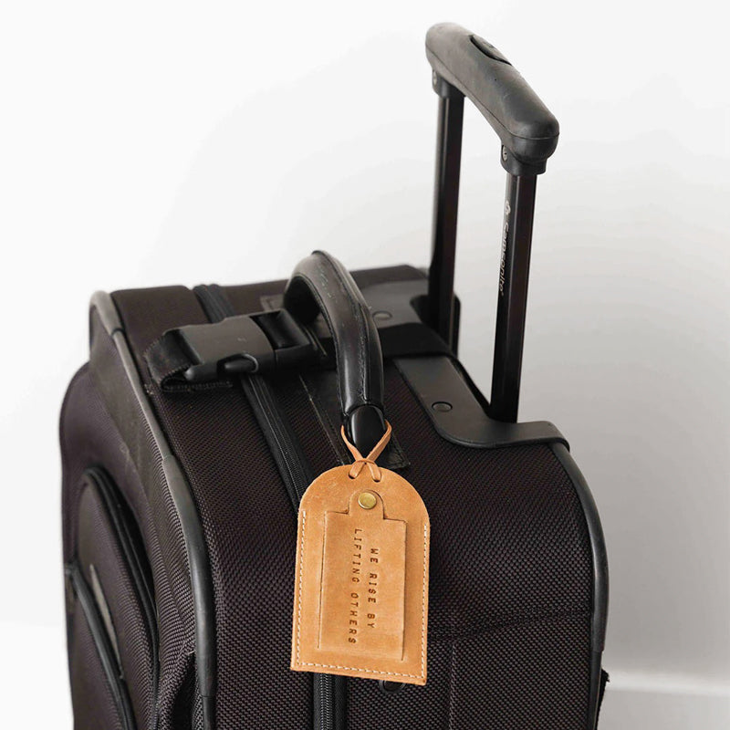 Premium full-grain leather luggage tag displayed with travel essentials, combining style with function.