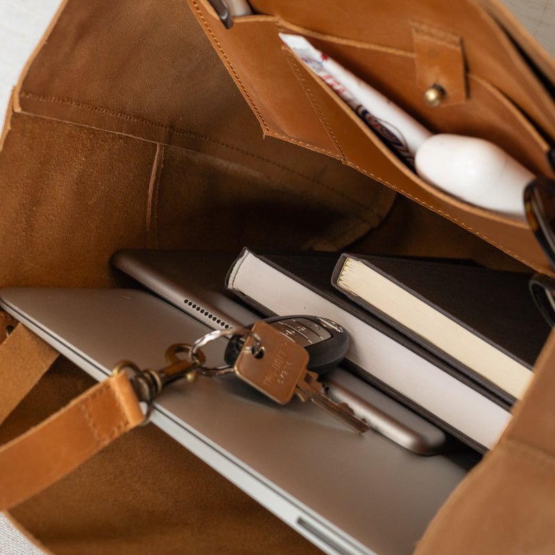 Traveler's Tote showcasing gold grommet feet and durable construction, an essential leather tote bag for women.