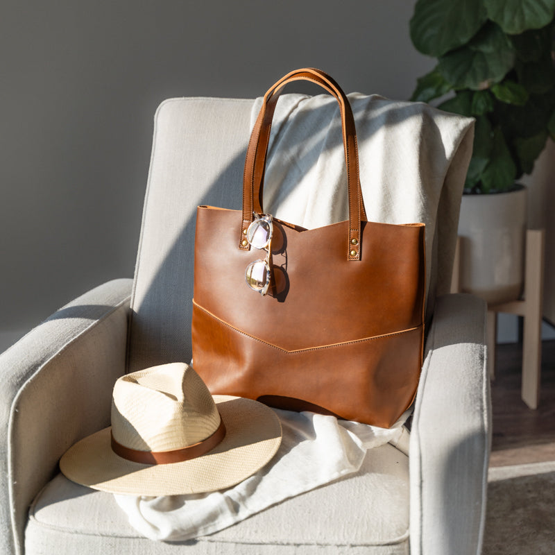 Traveler's Tote displayed with accessories, highlighting its elegance as a leather tote bag for women.