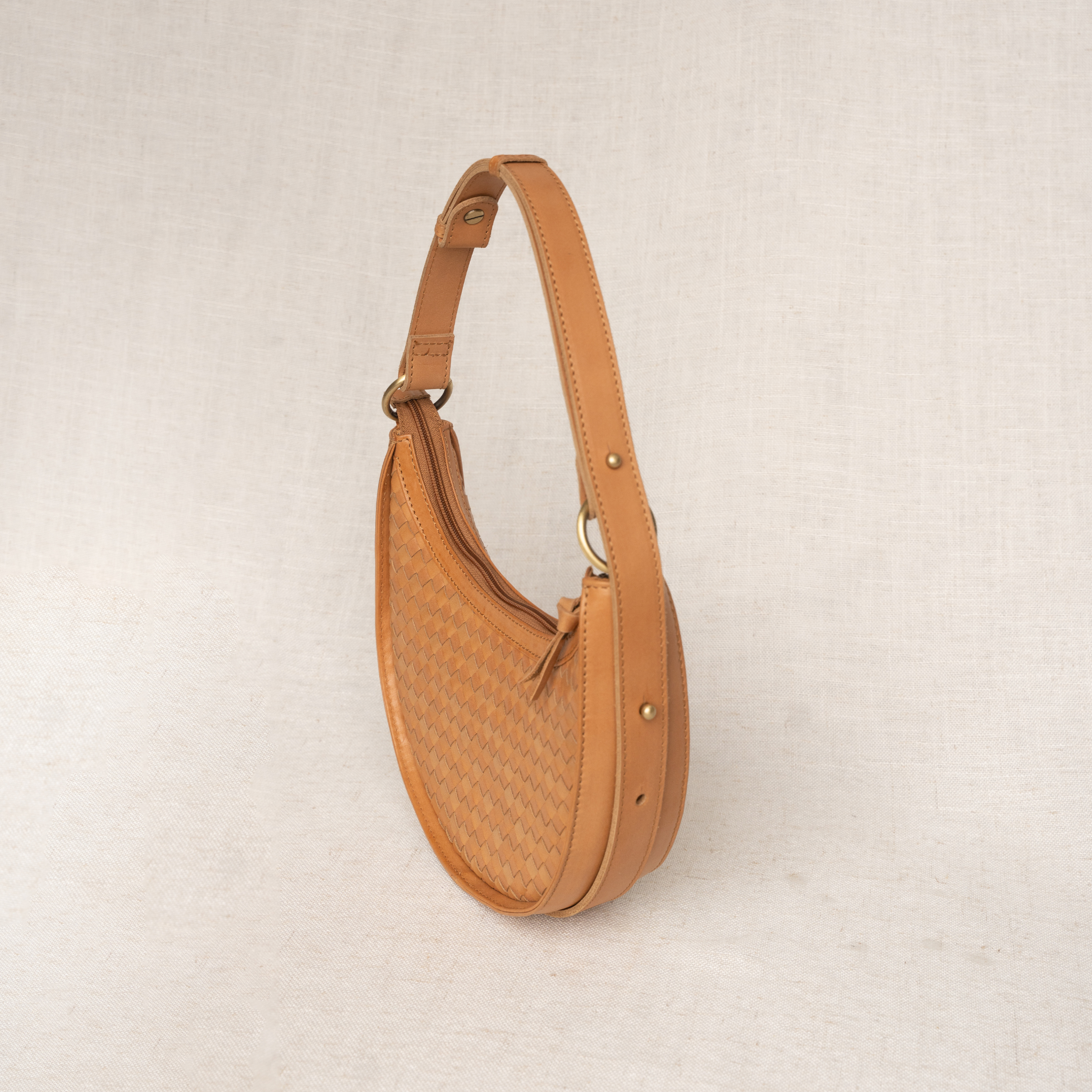 Brown leather handbag on a beige background