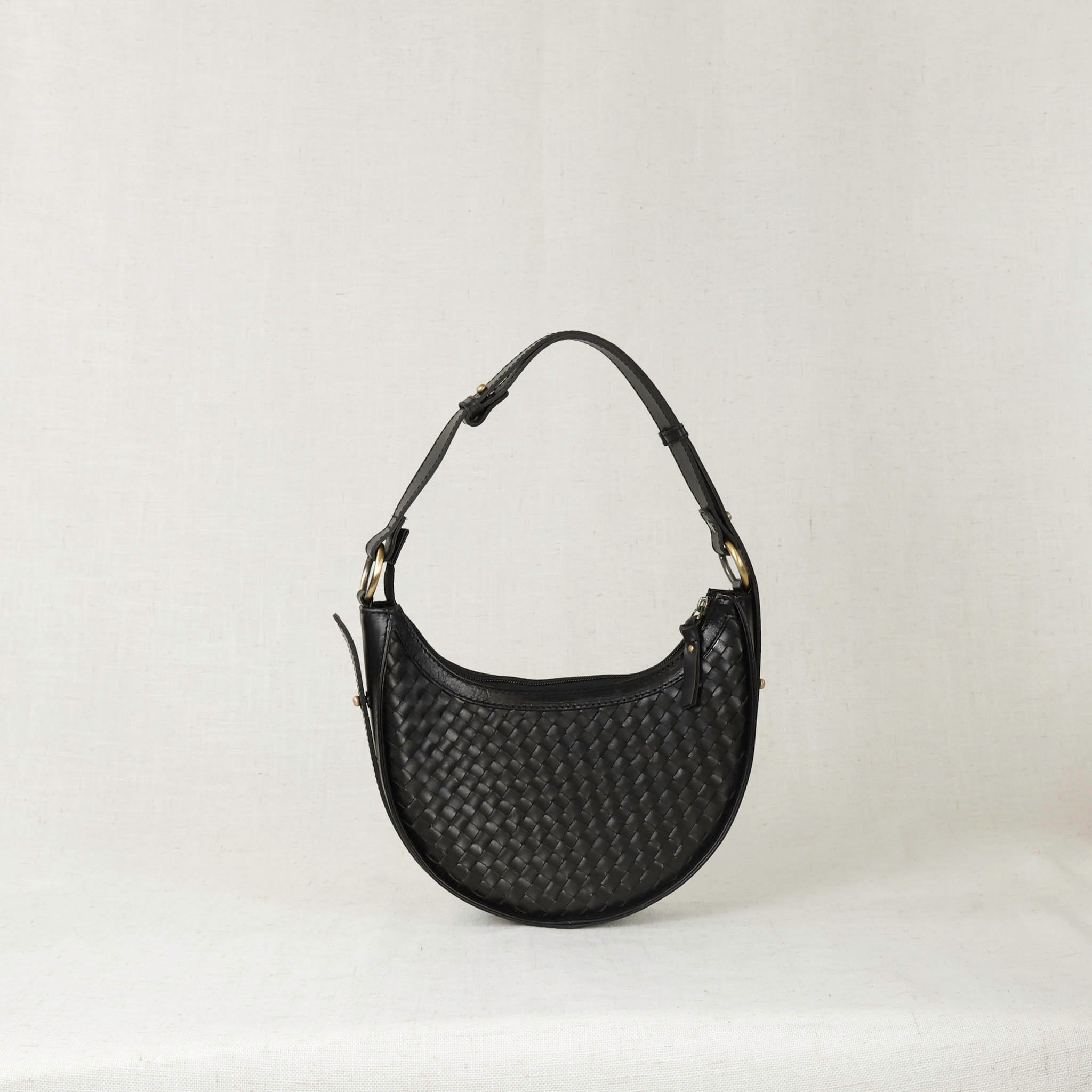 Black woven handbag on a light gray background