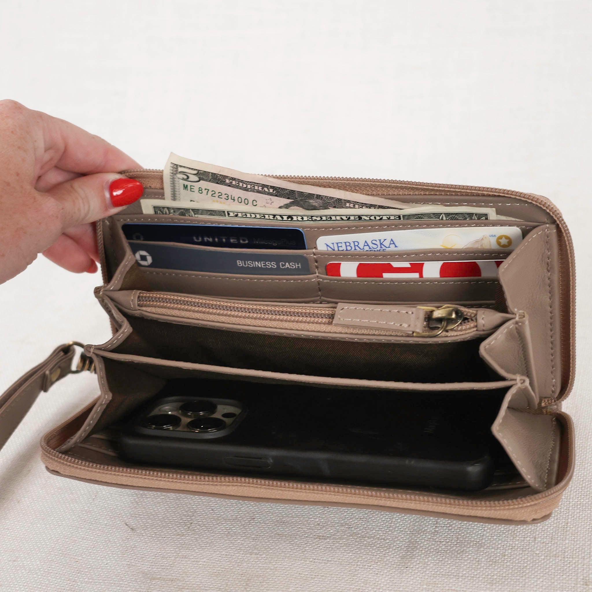 zipper wallet in taupe color leather showing the inside of the wallet with phone inside