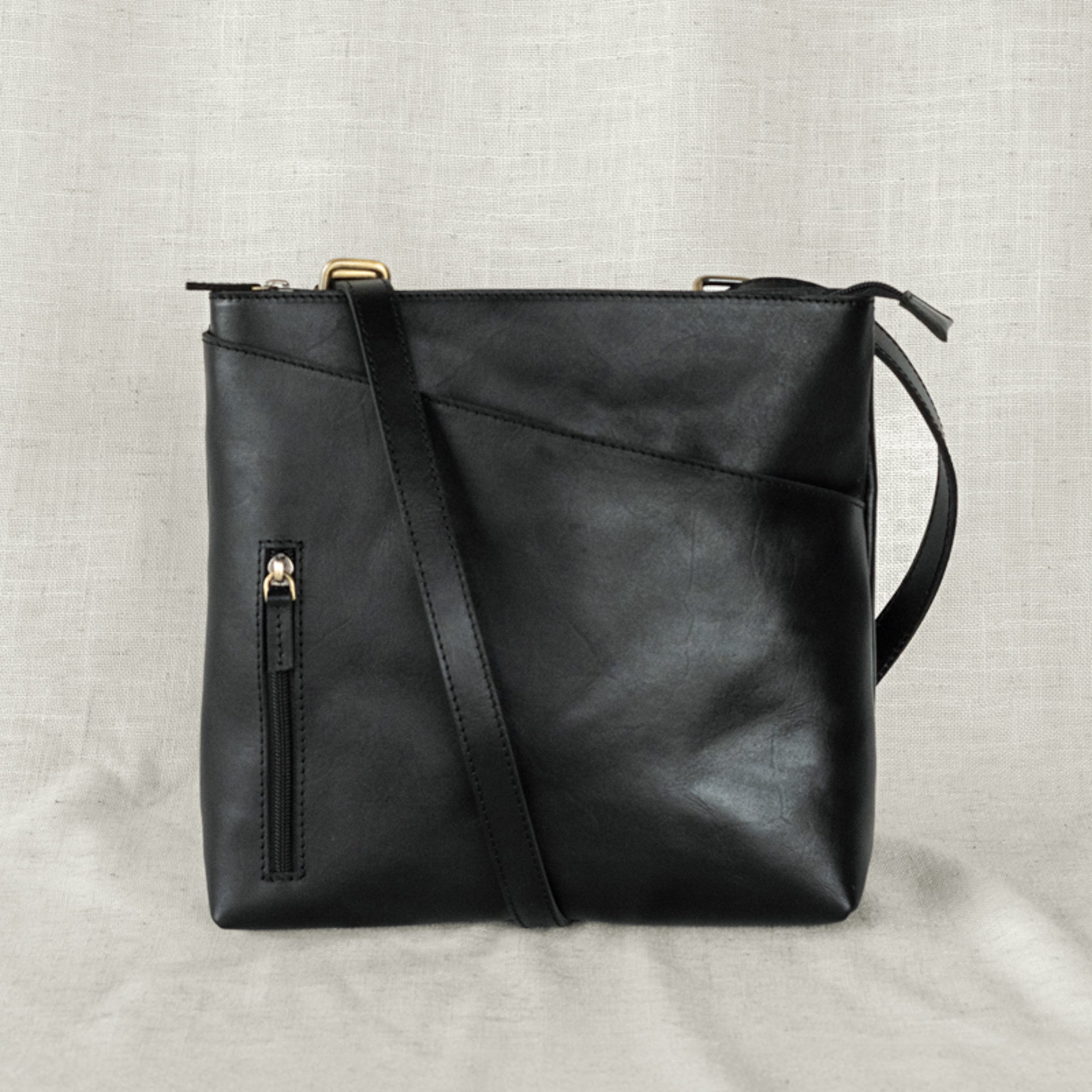 The Sojourner - 2-in-1 Backpack & Crossbody worn as a crossbody, highlighting its versatility as a convertible leather backpack.