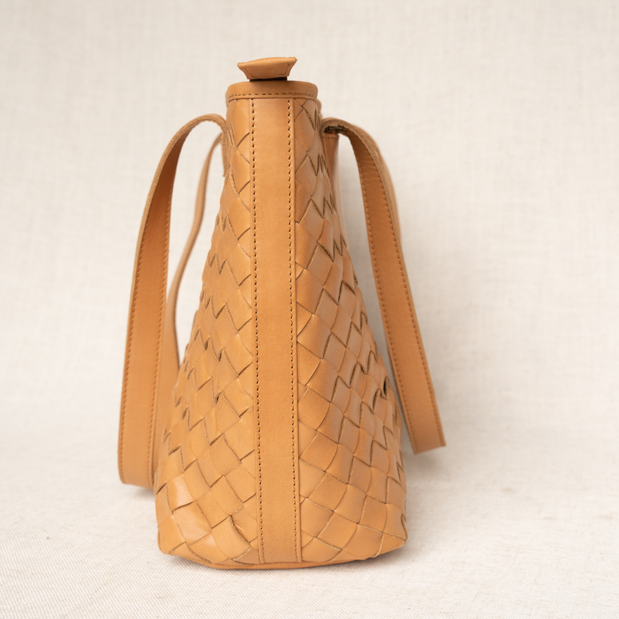 Tara Tote displayed outdoors, emphasizing its chic design as a trendy hand woven leather tote.