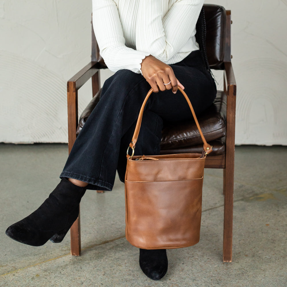 The Newport Tote filled with essentials, showcasing its spacious interior as an everyday leather bucket tote bag.