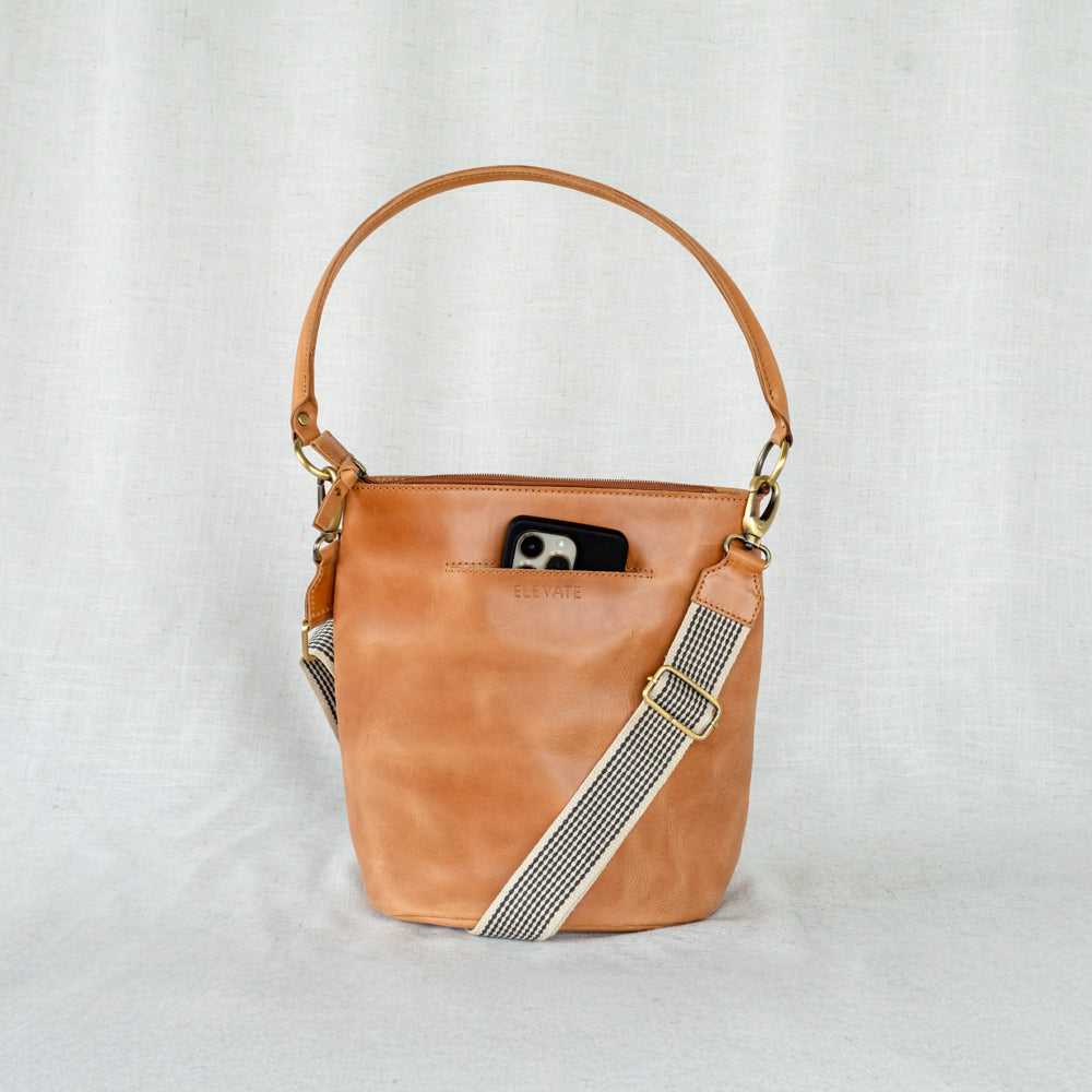 The Newport Tote being worn crossbody, highlighting its versatility as a chic leather bucket tote bag.