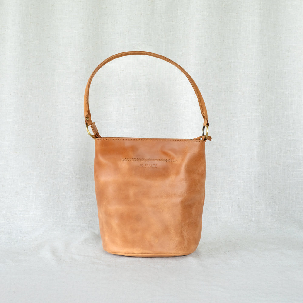 Side view of The Newport Tote, highlighting its sleek silhouette as a desirable leather bucket tote bag.