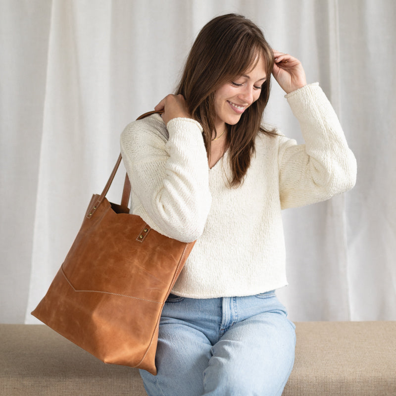 Traveler's Tote being carried by a woman, showcasing its stylish appeal as a leather tote bag for women.