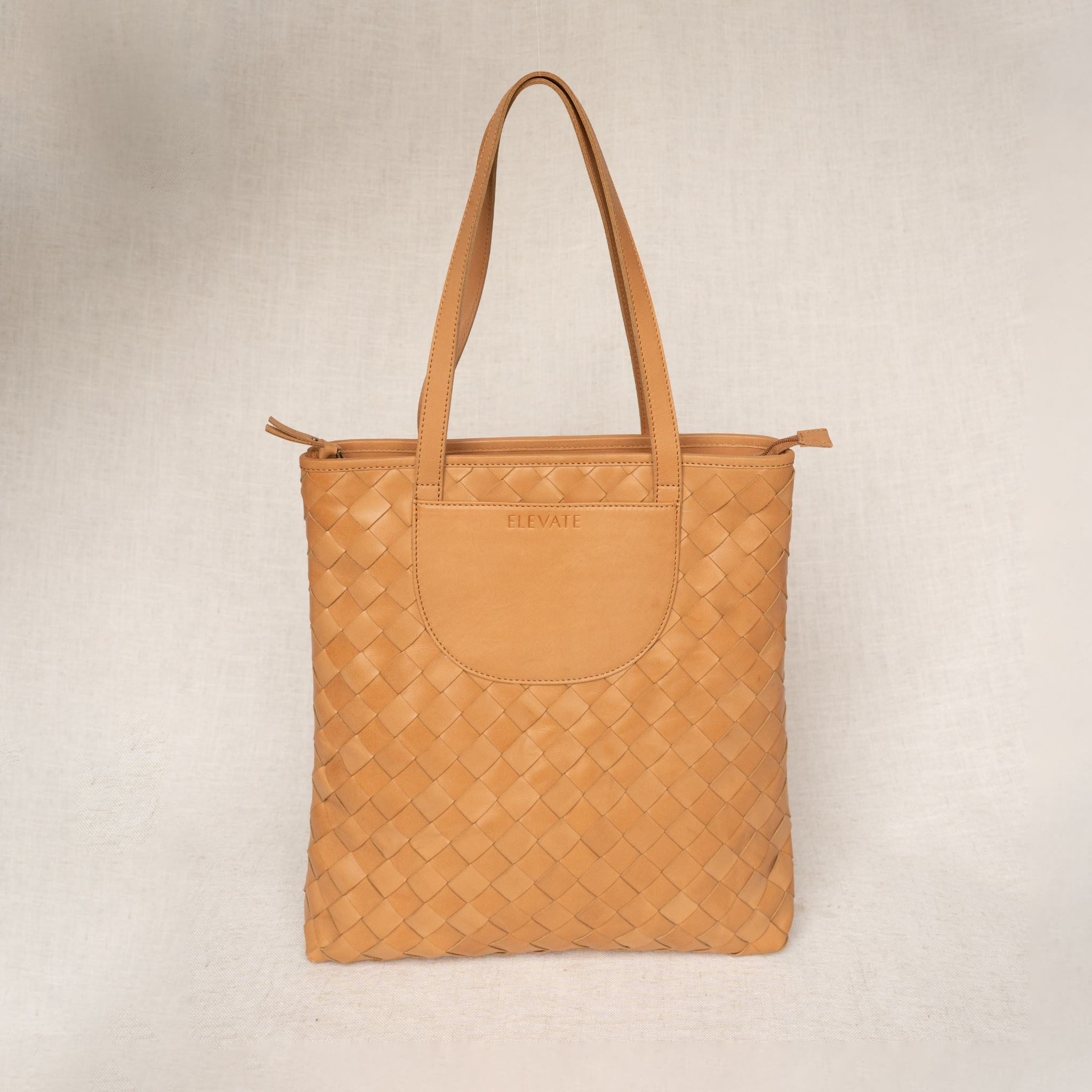 Tan woven handbag on a beige background