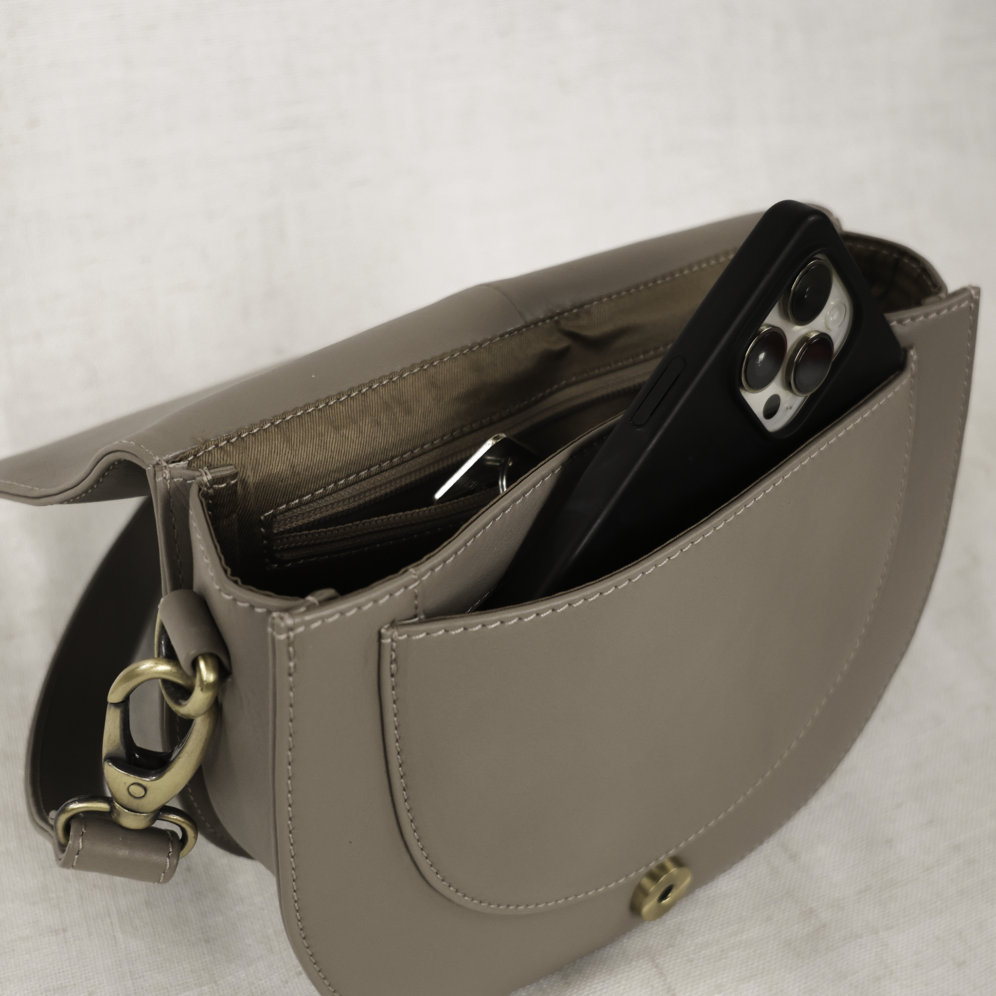 Stella Leather Saddle Bag worn crossbody with a matching leather strap, representing an elegant accessory for any outfit.