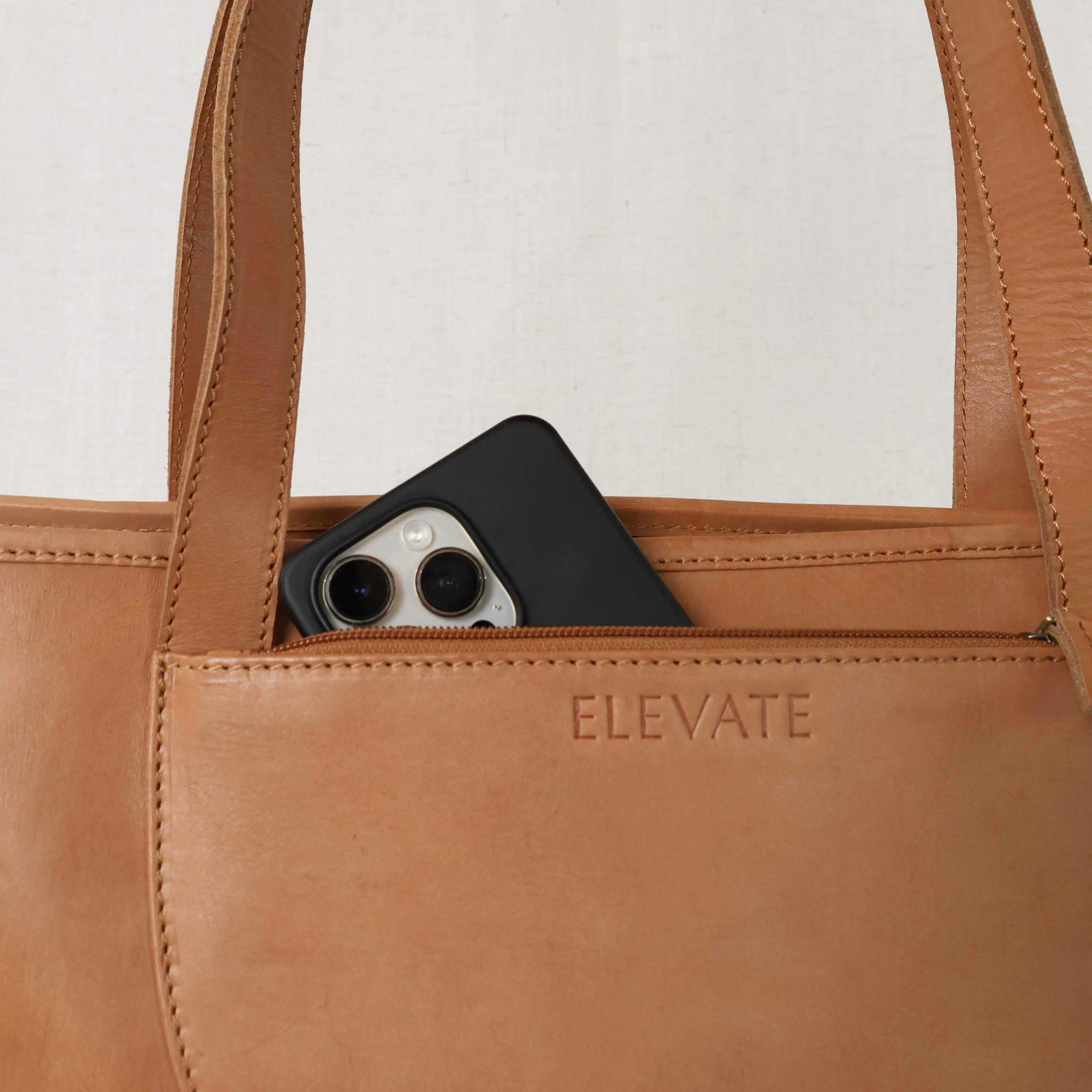 The stylish half-moon zippered exterior pocket of the Tara Tote - Premium Leather Tote With Laptop Sleeve for quick access.
